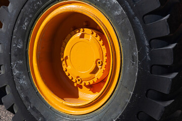 Wheel of heavy wheeled equipment. Excavator wheel with yellow disc.