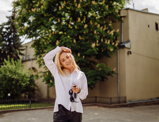 Portrait of a young business woman blonde smiling on a background of a city