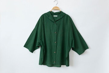 Green woman clothes is clothes hanger on white background.close up