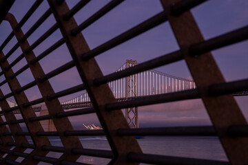 Obraz premium Oakland bay bridge California taken through the railing of Pier 14. High-quality photo was taken at blue hour