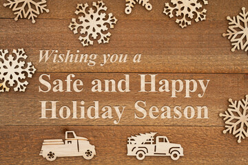 Safe and Happy Holiday Season message with wood snowflakes and retro trucks