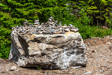 Pyramids of stones in Karelia. Pyramids of stones on background of green forest. Natural stones on top of each other. Balancing stones in the forest.