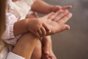 caucasian baby holding mom's finger. High quality photo