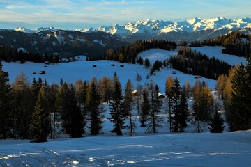 Zur Blauen Stunde auf den winterlichen Armentara Wiesen am  Heiligkreuzkofel in den Dolomiten mit dem schneebedeckten Alpen -Hauptkamm im Hintergrund