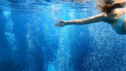 The girl swims. Shooting from under the water