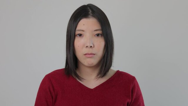 Young Japanese woman opens her eyes and stares the camera. Emotionless, Still, Protest. 25P.