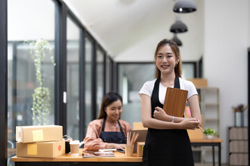 Portrait young attractive asia female owner startup business look at camera working together with box at home, procurement, omnichannel commerce online concept.