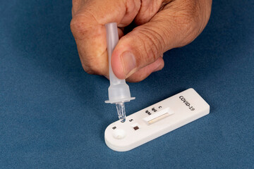 Covid-19 rapid test with person dripping the reagent