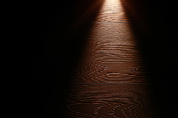 strong light source from flash light shining on the floor in the dark. Surface with copy space....