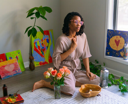 Young woman putting on herbal fragrance