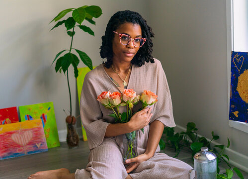 Young Black woman with bouquet of roses
