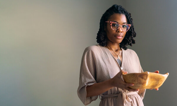 Young Black woman with bowl of rose petals