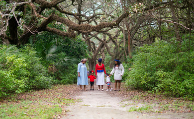 Fototapeta premium Woman and children walking in the park