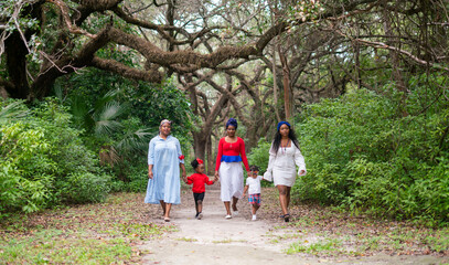 Fototapeta premium Woman and children walking in the park