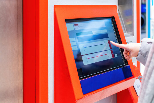 Woman touch on screen of automatic ticketing system