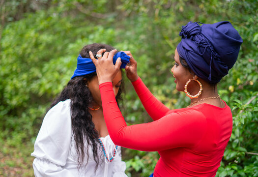 Woman helping woman put on headwrap