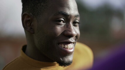 Happy black African man smiling and laughing portrait face close-up