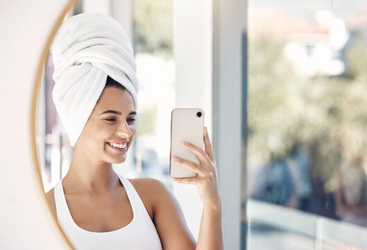 portrait, phone selfie and woman, towel and bathroom for skincare, beauty and cleaning in mirror reflection. Face, girl and smile for picture after facial treatment, grooming and hygiene with a smile