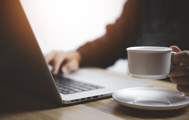 Man working in front of a laptop with hot coffee with smoke and steam