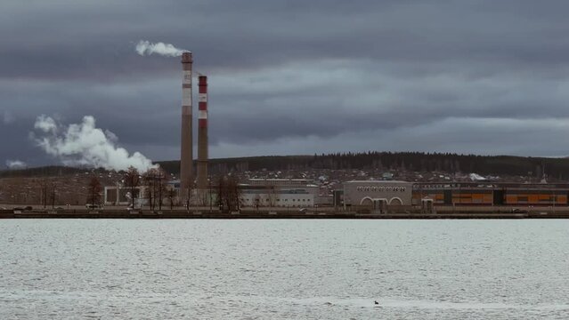 View of the tall chimneys of an industrial enterprise with a chimney polluting the atmosphere. The plant for the production of strategic intercontinental missiles "Topol-M". Russia, Votkinsk 2022