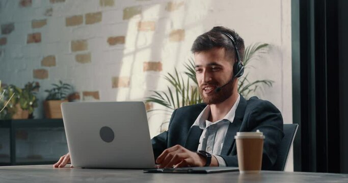 Successful male manager amicably negotiates a win-win deal with a representative of another company using an online connection. A young man communicates via video link in an informal atmosphere.