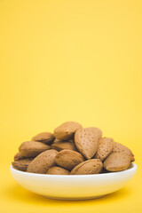 almonds in a plate on a yellow