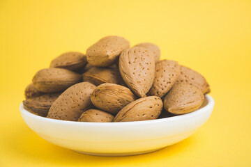 almonds in a plate on a yellow