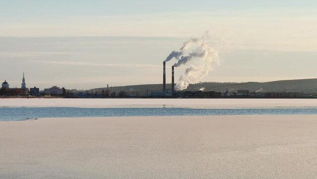 View of the tall chimneys of an industrial enterprise with a chimney polluting the atmosphere. The plant for the production of strategic intercontinental missiles "Topol-M". Russia, Votkinsk 2022