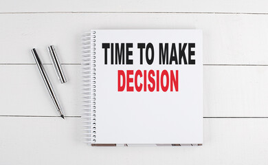TIME TO MAKE DECISION text written on notebook on the wooden background