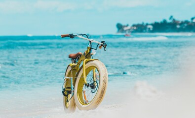 Yellow bicycle with white wheels on the beach shore