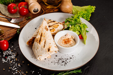 Tasty dish of pita with meat and vegetables on wooden background