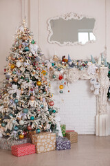 Christmas and New Year card with decorated fur tree and gifts on white wall and stucco fireplace background.