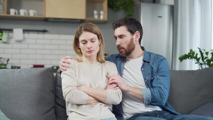 Guilty bearded husband trying to apologize to offended worried young woman after family conflict Young man calms and supports wife with serious problems at work or personal mental health crisis - Powered by Adobe