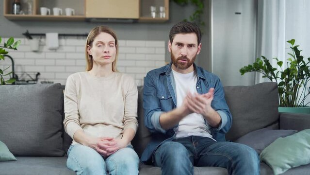 Webcam view of stressed married couple looking at the camera arguing and talking with psychotherapist about family conflict disagreement discussing relationship at online counselling session at home