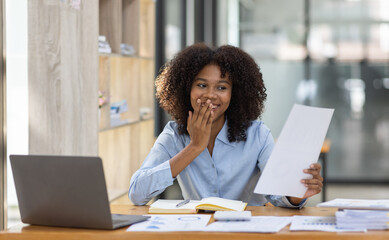 Successful african american accountant business woman work documents tax on laptop computer in office. finance investment economy and marketing research concept.