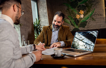 Two businessman having a business meeting in cafe.