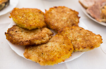 Fried grated potato pancakes with sour cream on white plate