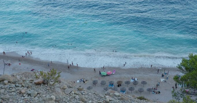 Top view - beach umbrellas are installed at the sea coast, people having rest at the bech