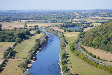 View of the landscape and the Weser from the Porta-Kanzel in Porta Westfalica. Green nature with a river, fields and hills.
