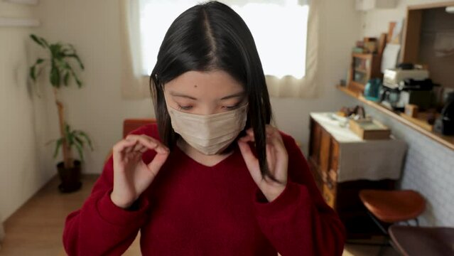 Japanese young woman put a mask on. Tired, Reluctant, Uncomfortable. Dolly in.