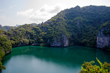 Beautiful lake of Ko Mae Ko island with tropical plants on rocky cliffs