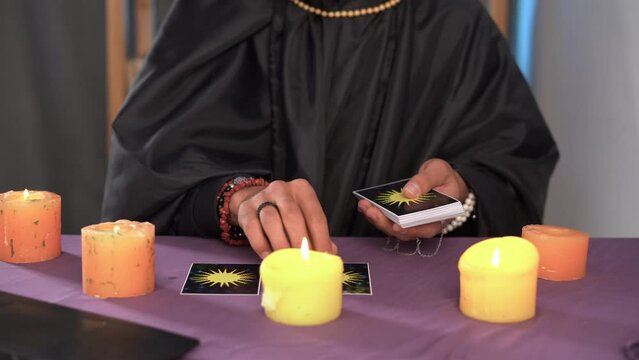 fortune teller man layout a tarot cards in front of the laptop screen while having an online session. Modern technology.