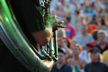 A person playing a wind instrument at a festival in front of a large audience.The concept of a...