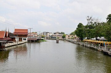 Obraz premium BANGKOK, THAILAND - December 02, 2022 : Tourist Passenger Boat leading tourists to view the houses along the canal and the ways of villagers along the canal in the Chao Phraya River Canal.
