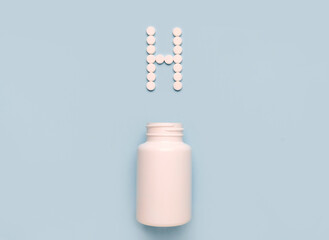 Chemical element Hydrogen H icon from tablets and drug bottle on blue background. Colltction of vitamin and minerals