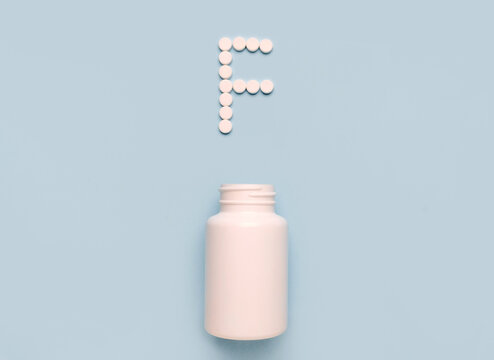 Сhemical element Fluorum, F icon from tablets and drug bottle on blue background. Colltction of vitamin and minerals
