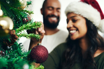 Christmas, decorating tree and happy black couple celebrate holiday season with love, happiness and festive bonding. Black woman, man smile together and enjoy decorate Christmas tree in living room
