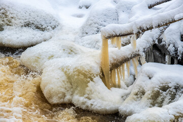 Icicle hanging on a tree branch at a creek