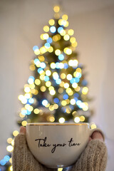 Take your time Girl Holding a Cup of Tea and Christmas Tree Bokeh