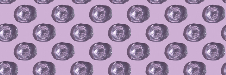 Seamless pattern. Drops of transparent cosmetic gel or serum with hyaluronic acid on a lilac background. Wellness and beauty concept. Top view.
